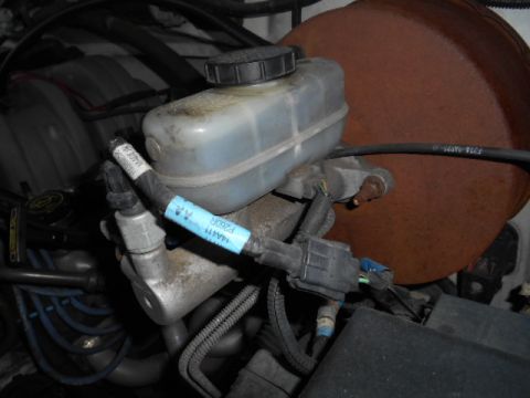 1994 Ford Bronco - Close-up of engine components, including a brake fluid reservoir with a visible part number.