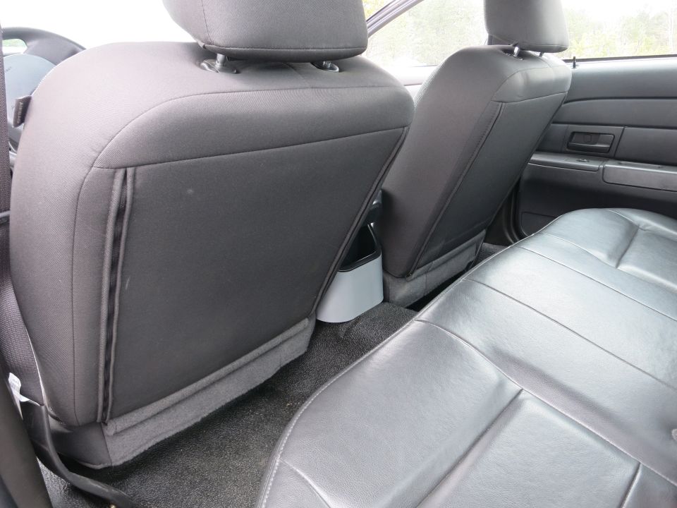 Rear seats of a 2001 Ford Crown Victoria, showing black leather bench seat and fabric-covered front seatbacks