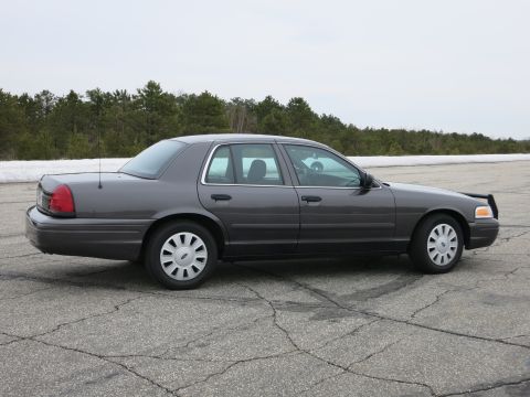 2001 Ford Crown Victoria - This Ford Crown Victoria is seen from the side, parked outdoors on a cloudy day.