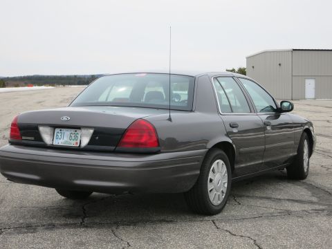 2001 Ford Crown Victoria - Rear view of a dark grey 2001 Ford Crown Victoria sedan parked on asphalt.