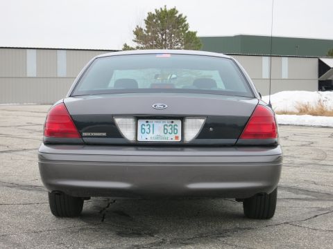 2001 Ford Crown Victoria - Rear view of a 2001 Ford Crown Victoria, identified by its distinct taillights and body style. The license plate is clearly visible.