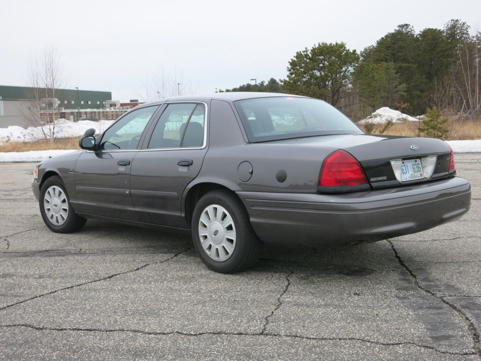 Grey Ford Crown Victoria parked on cracked asphalt. License plate reads 631-636
