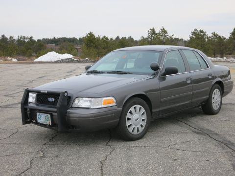 2001 Ford Crown Victoria - This Ford Crown Victoria, likely a police vehicle, is shown from the front three-quarter view on an overcast day.