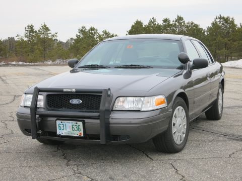 2001 Ford Crown Victoria - This 2001 Ford Crown Victoria, equipped with a push bar and distinctive wheels, is captured in a three-quarter front view.