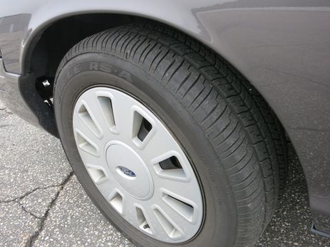 2001 Ford Crown Victoria - Close-up of the wheel and fender of a grey 2001 Ford Crown Victoria.