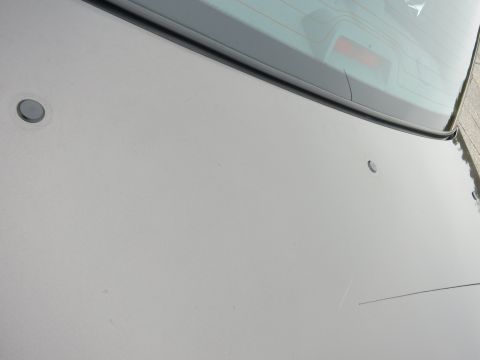 2001 Ford Crown Victoria - The rear of a grey vehicle is shown, with the trunk and rear window visible. There are two circular indentations on the trunk lid.