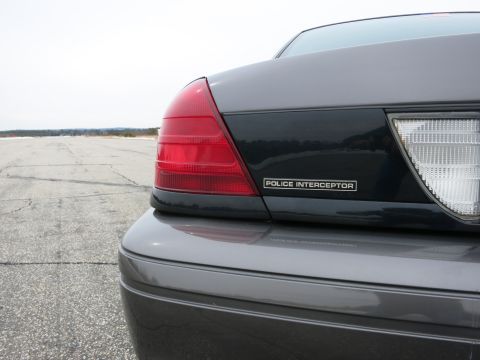 2001 Ford Crown Victoria - The rear of a grey 2001 Ford Crown Victoria Police Interceptor is visible from the right side.