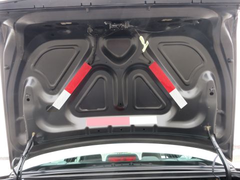 2001 Ford Crown Victoria - The inside of a car's trunk, showing the lid's underside with reflective safety markers.