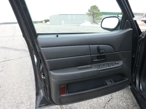 2001 Ford Crown Victoria - Interior view of a car door panel, with a glimpse of the exterior landscape.