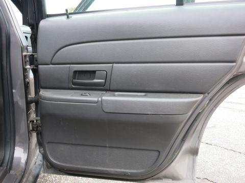 2001 Ford Crown Victoria - The interior door panel of a 2001 Ford Crown Victoria, showing the handle and window controls.