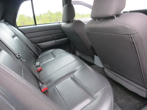 2001 Ford Crown Victoria - Rear interior view of a vehicle, showing gray leather seats and seat belts.