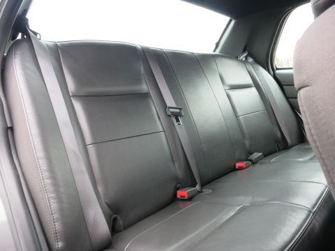 2001 Ford Crown Victoria - Interior view of a car's back seat, showing the leather upholstery and seatbelt system.