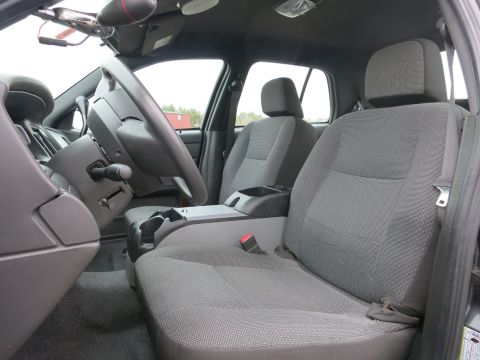 2001 Ford Crown Victoria - The interior of a car shows gray cloth seats and the steering wheel.