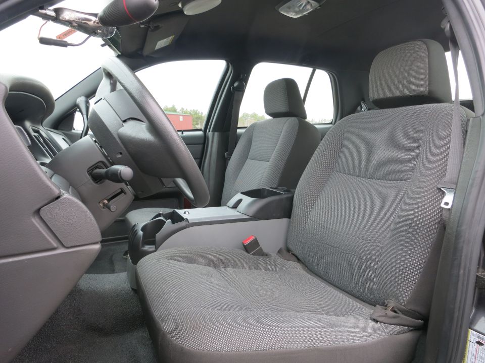 Car interior with gray cloth seats, steering wheel, and center console