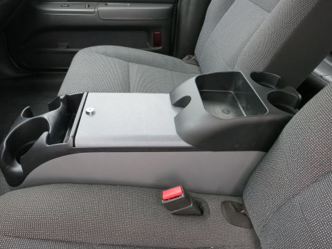 2001 Ford Crown Victoria - The interior of a 2001 Ford Crown Victoria shows a gray console with cup holders and a lock, adjacent to the gray fabric seats and seatbelt.