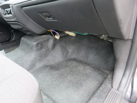 2001 Ford Crown Victoria - Exposed wiring and textured floor mat visible inside a vehicle's cabin.