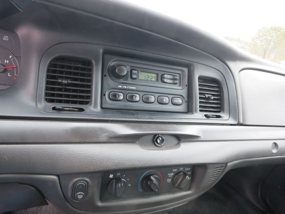 Dashboard of a 2001 Ford Crown Victoria showing the radio and climate controls