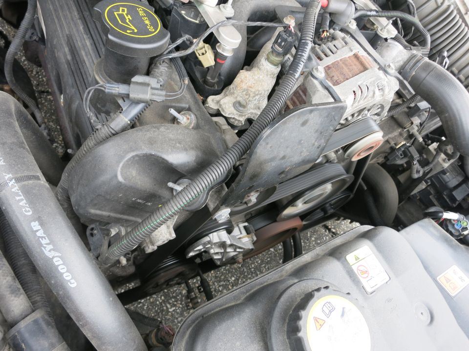 Engine bay with visible belts and pulleys. Goodyear Galaxy A/T tire visible