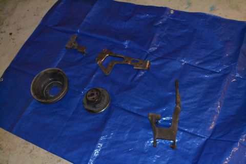 1981 Ford F-250 - Various metal vehicle components are displayed on a blue tarp, suggesting a repair or restoration project.
