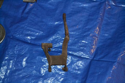 1981 Ford F-250 - A close-up view of a metal bracket resting on a blue tarp, likely a vehicle part.
