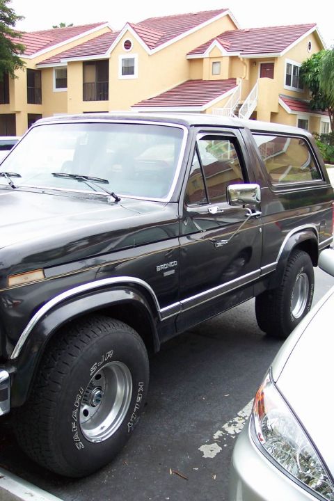 1986 Ford Bronco - This 1986 Ford Bronco is seen in a three-quarter front view, parked next to another vehicle.