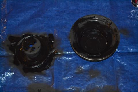 1981 Ford F-250 - Two automotive parts, a pulley and an oil pan, are shown covered in oil on a blue tarp.