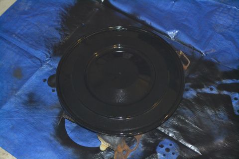 1981 Ford F-250 - A freshly painted black air cleaner lid rests on a blue tarp, with some overspray visible.