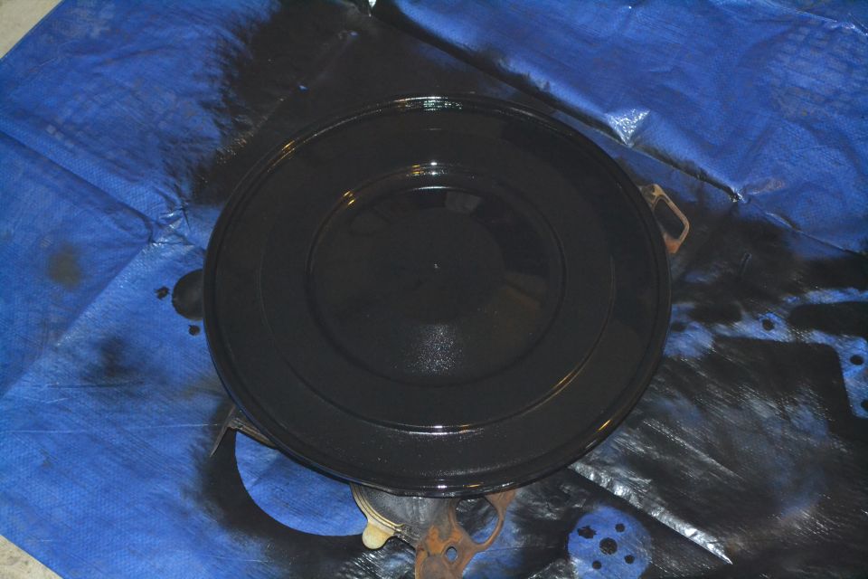 Black air cleaner lid on blue tarp, looks like it was just painted