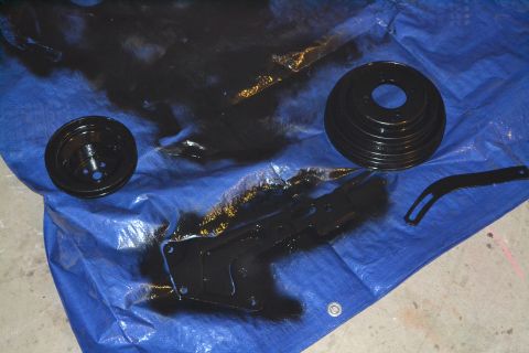 1981 Ford F-250 - Car parts are laid out on a blue tarp, some with black paint overspray.