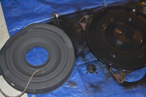 1981 Ford F-250 - Two parts of an air cleaner assembly are shown on a blue tarp, one is black and the other is a matte gray.