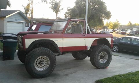 1968 Ford Bronco - This lifted 1968 Ford Bronco features a two-tone red and white paint scheme and aggressive off-road tires.