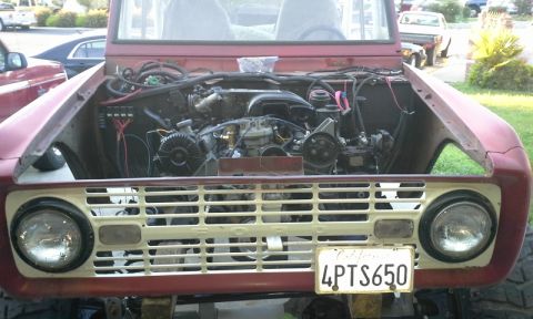 1968 Ford Bronco - Front view of a 1968 Ford Bronco, hood up, revealing the engine compartment and grille.