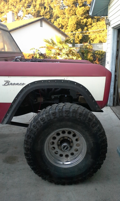 1968 Ford Bronco - Close-up of a classic Ford Bronco's front fender and wheel, showing its off-road modifications.