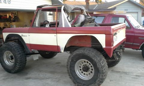 1968 Ford Bronco - This lifted 1968 Ford Bronco features a two-tone red and white paint scheme and aggressive off-road tires.