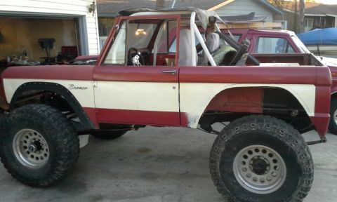 1968 Ford Bronco - Side view of a modified 1968 Ford Bronco, a roll cage and lifted suspension.