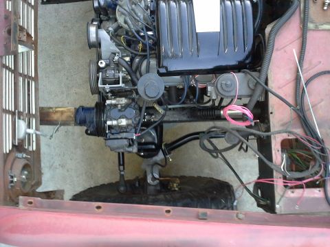 1968 Ford Bronco - Close-up view of an engine and chassis components within a red vehicle.
