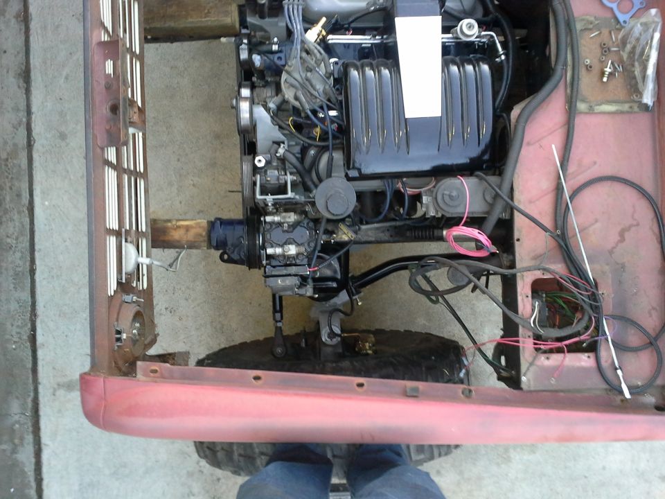 Red vehicle engine bay with exposed engine and wiring