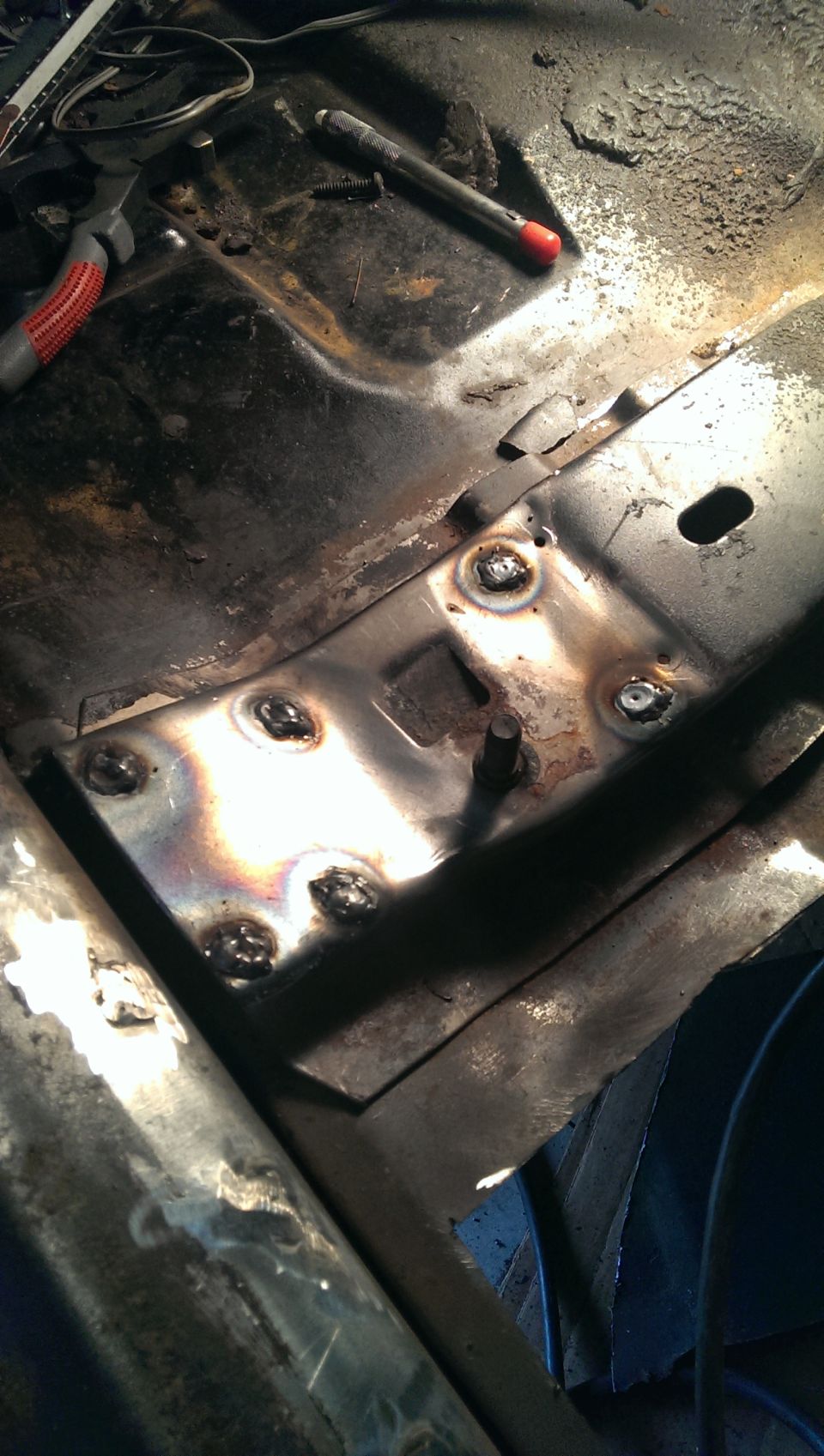 welded metal patch on vehicle floor