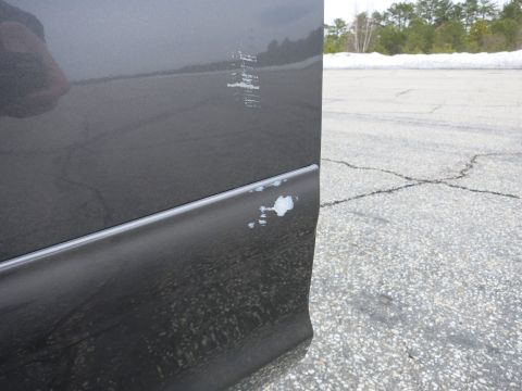 2001 Ford Crown Victoria - The side of a car shows damage with paint scraped off, revealing primer underneath.