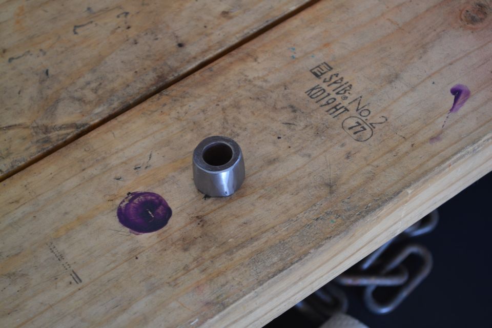 Metal bushing and purple ink splotches on wooden planks with stamped markings