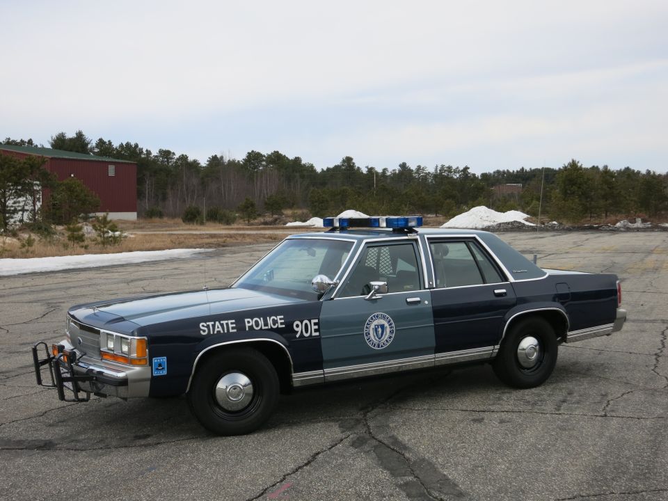 Massachusetts State Police Ford sedan cruiser, front three-quarter view in paved lot