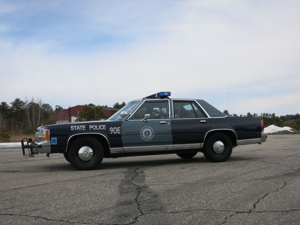 Massachusetts State Police Ford sedan, driver-side profile with light bar