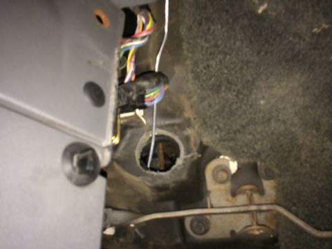 1991 Ford F-150 - Close-up view of a vehicle's interior wiring harness and a floor grommet.