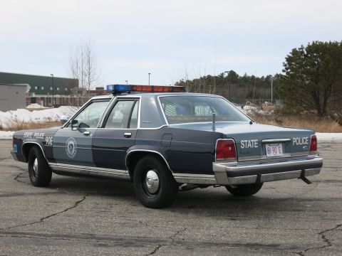 1991 Ford LTD Crown Victoria - Rear three-quarter view of a two-tone Massachusetts State Police Ford cruiser showing STATE POLICE lettering and a red MA license plate.