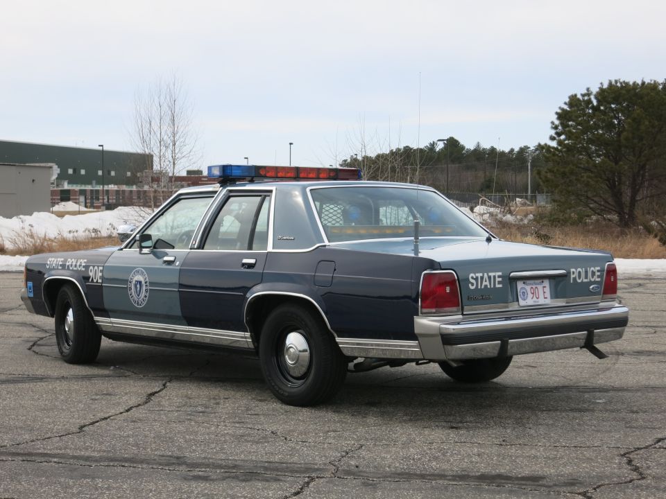 Massachusetts State Police Ford sedan, rear three-quarter with red and blue light bar