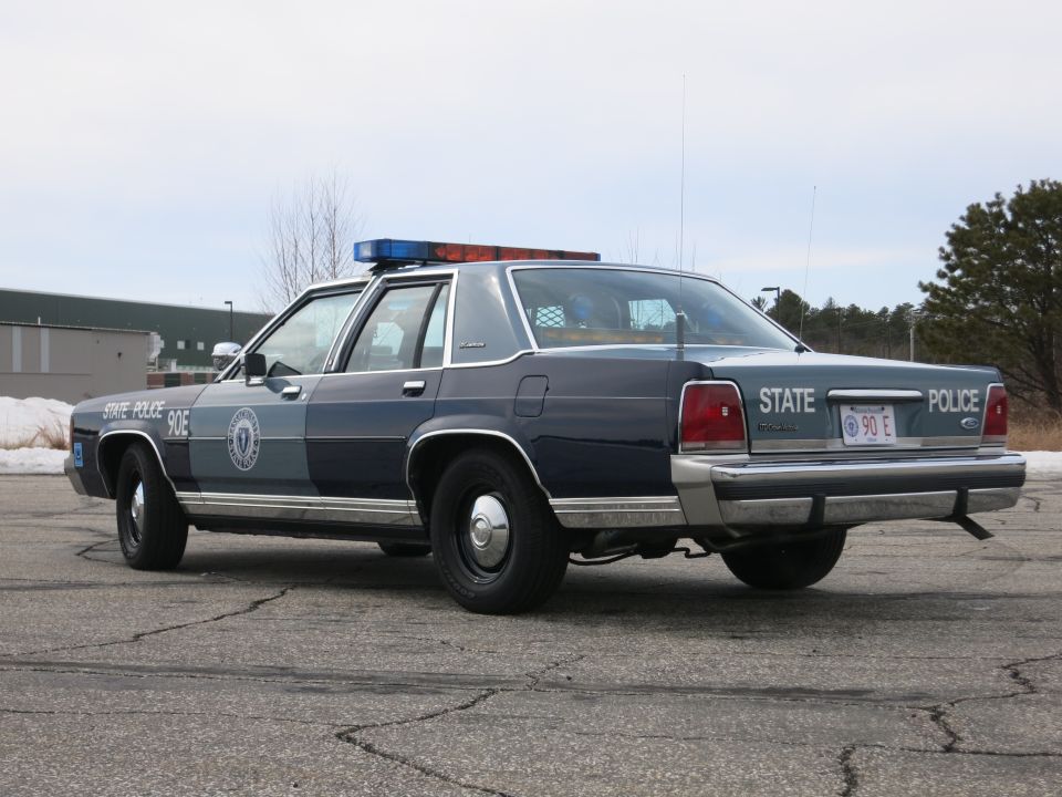 Massachusetts State Police Ford sedan, passenger-side rear three-quarter view