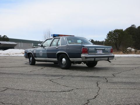 1991 Ford LTD Crown Victoria - Low rear three-quarter view of a two-tone Massachusetts State Police Ford cruiser with STATE POLICE rear lettering and MA plate.