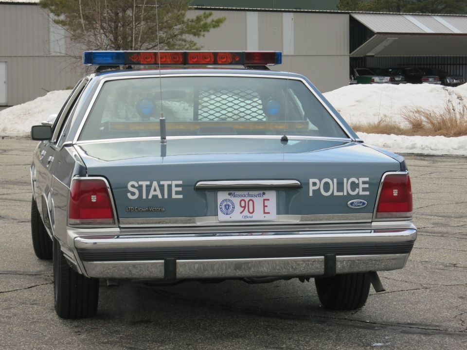 Rear view of blue Ford Crown Victoria State Police cruiser with red and blue light bar