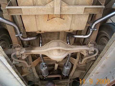 1978 Ford Bronco - The rear axle and dual exhaust system of a vehicle are shown from below.