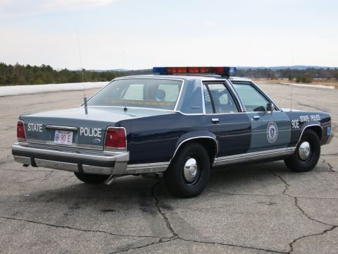 1991 Ford LTD Crown Victoria - Rear three-quarter view of a two-tone blue Ford LTD Crown Victoria State Police cruiser marked 90E with a door seal.